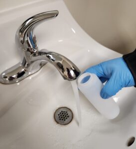 Photo of Well Water Sample Being Collected into Testing Bottle
